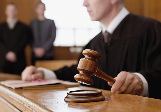 Judge holding gavel during litigation in courtroom